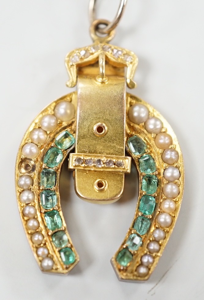 An early 20th century yellow metal, emerald, rose cut diamond and split pearl set horseshoe and buckle pendant, 33mm, gross weight 6 grams.